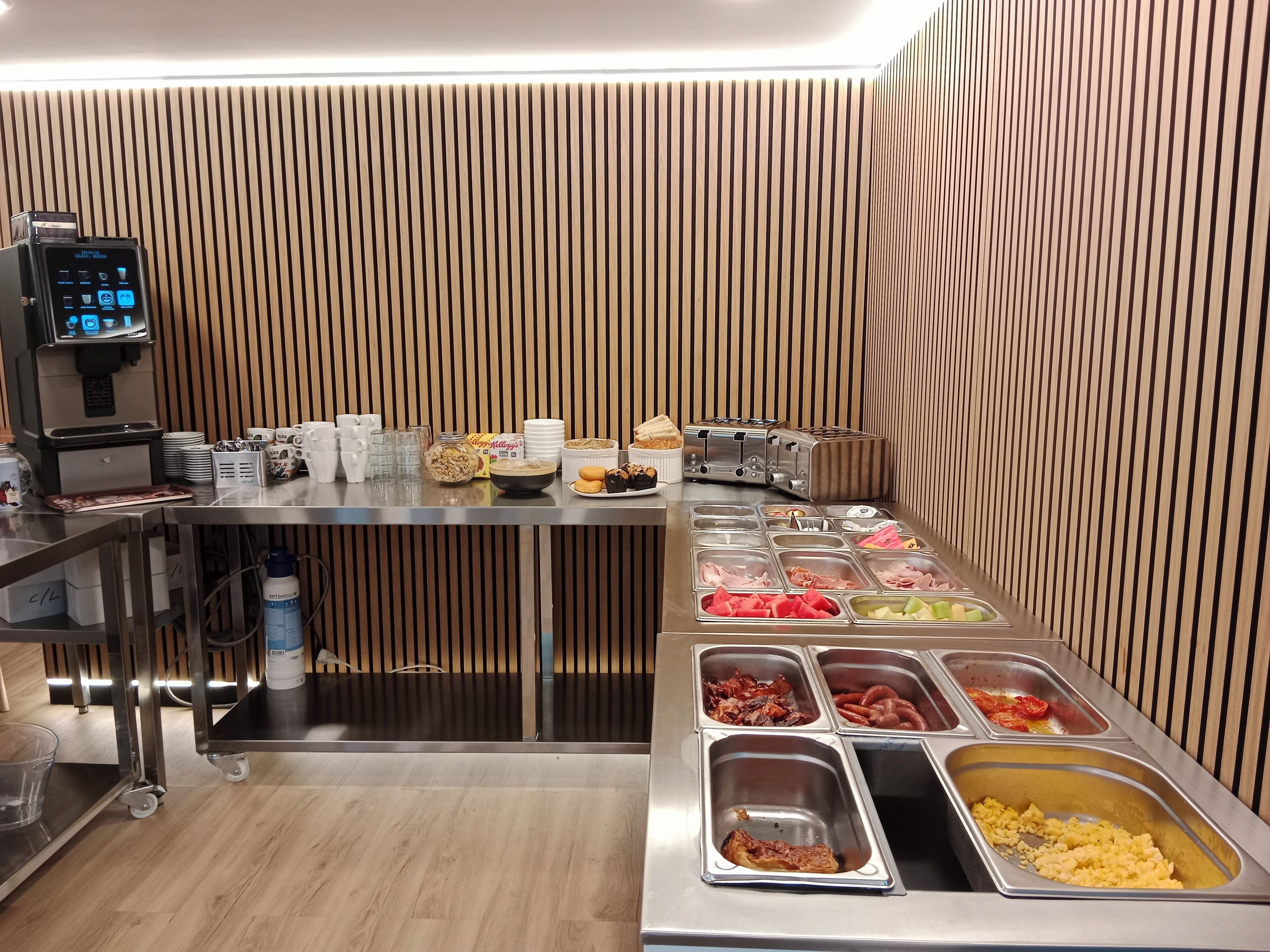 A buffet setup with various food items, a coffee machine, and a toaster.