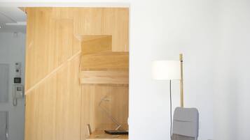 Quarto moderno com parede em madeira, uma escrivaninha com luminária e uma cadeira.