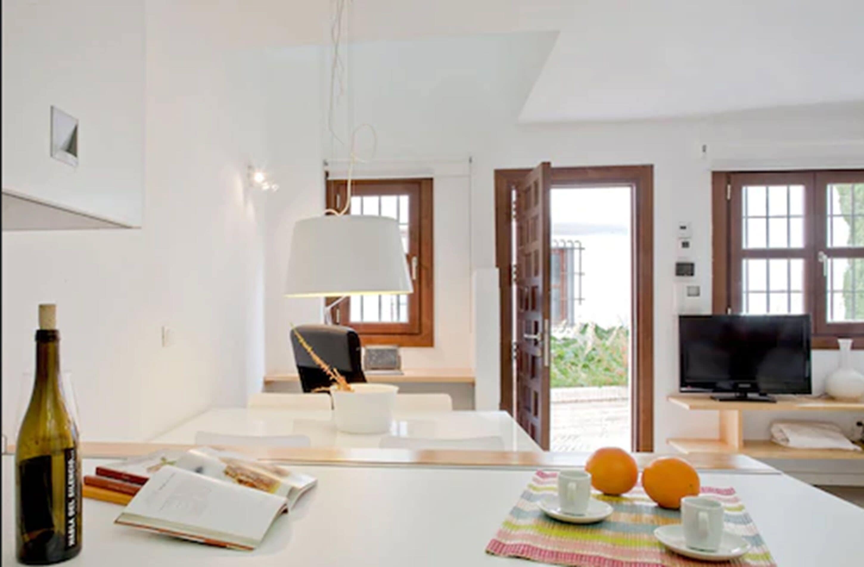A modern room with a dining area, a television, and a view of the outdoors.