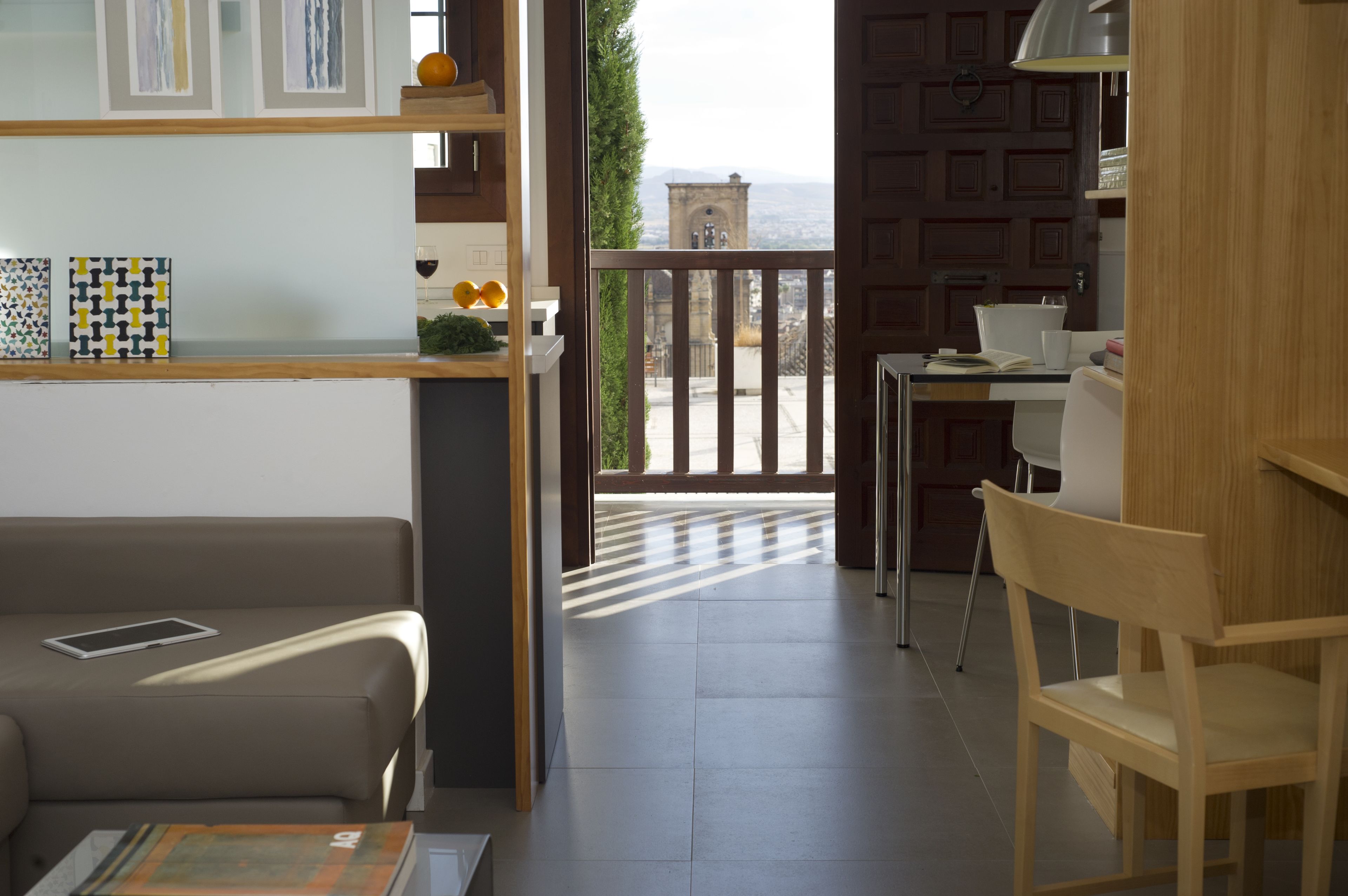 A modern living room with a sofa, a coffee table, and a view of a balcony with a railing.