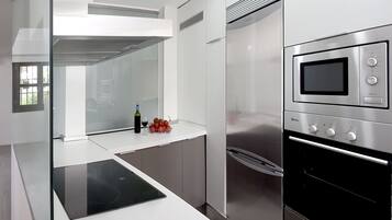 A modern kitchen with a built-in oven, a microwave, and a stovetop.