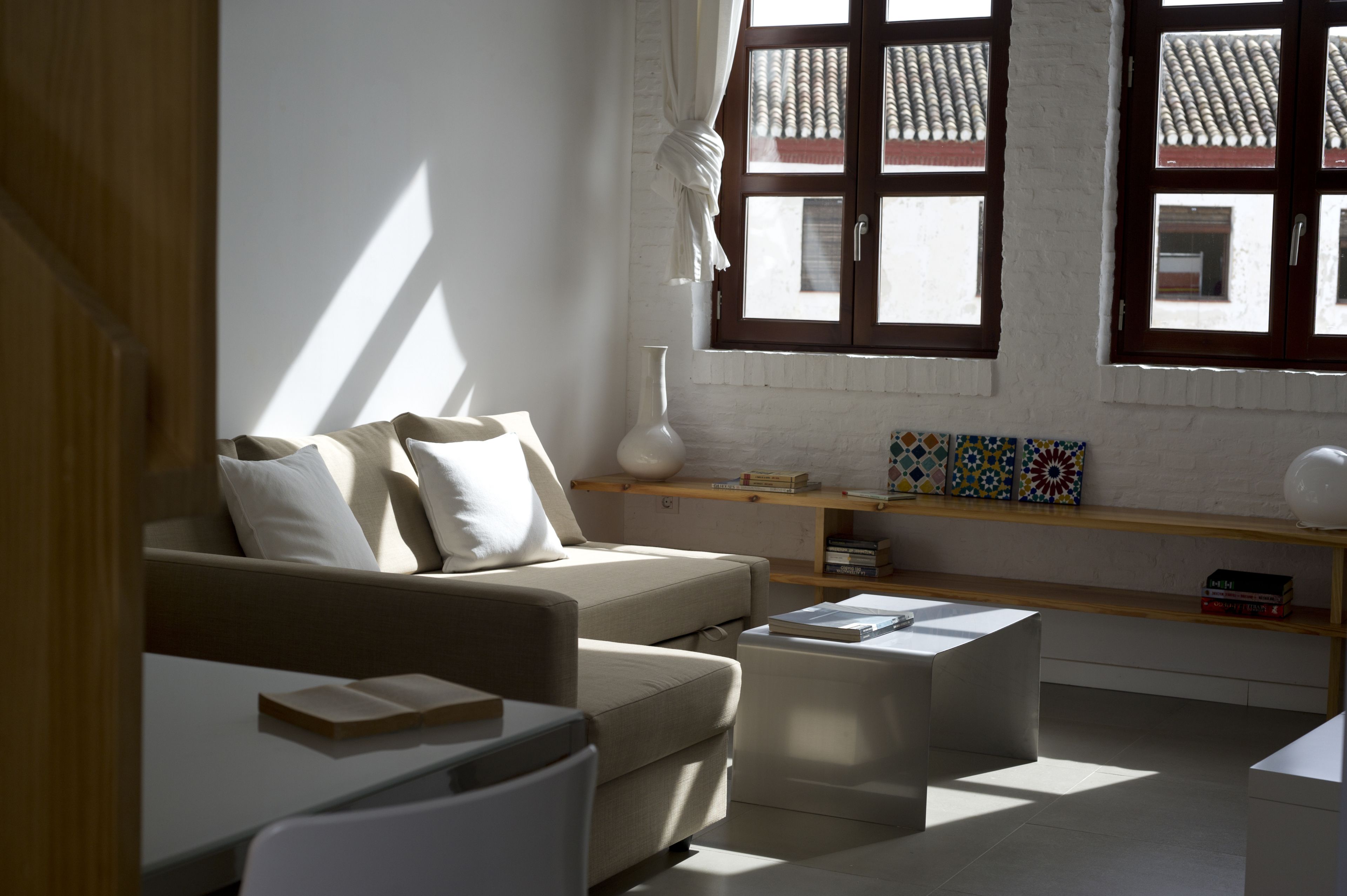 A modern living room with a sofa, coffee table, and a bookshelf.