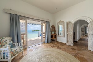 Amplia habitación con un gran ventanal que da a una vista panorámica, una silla de madera y un espejo decorativo.