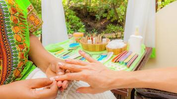 A close-up of hands receiving a manicure.