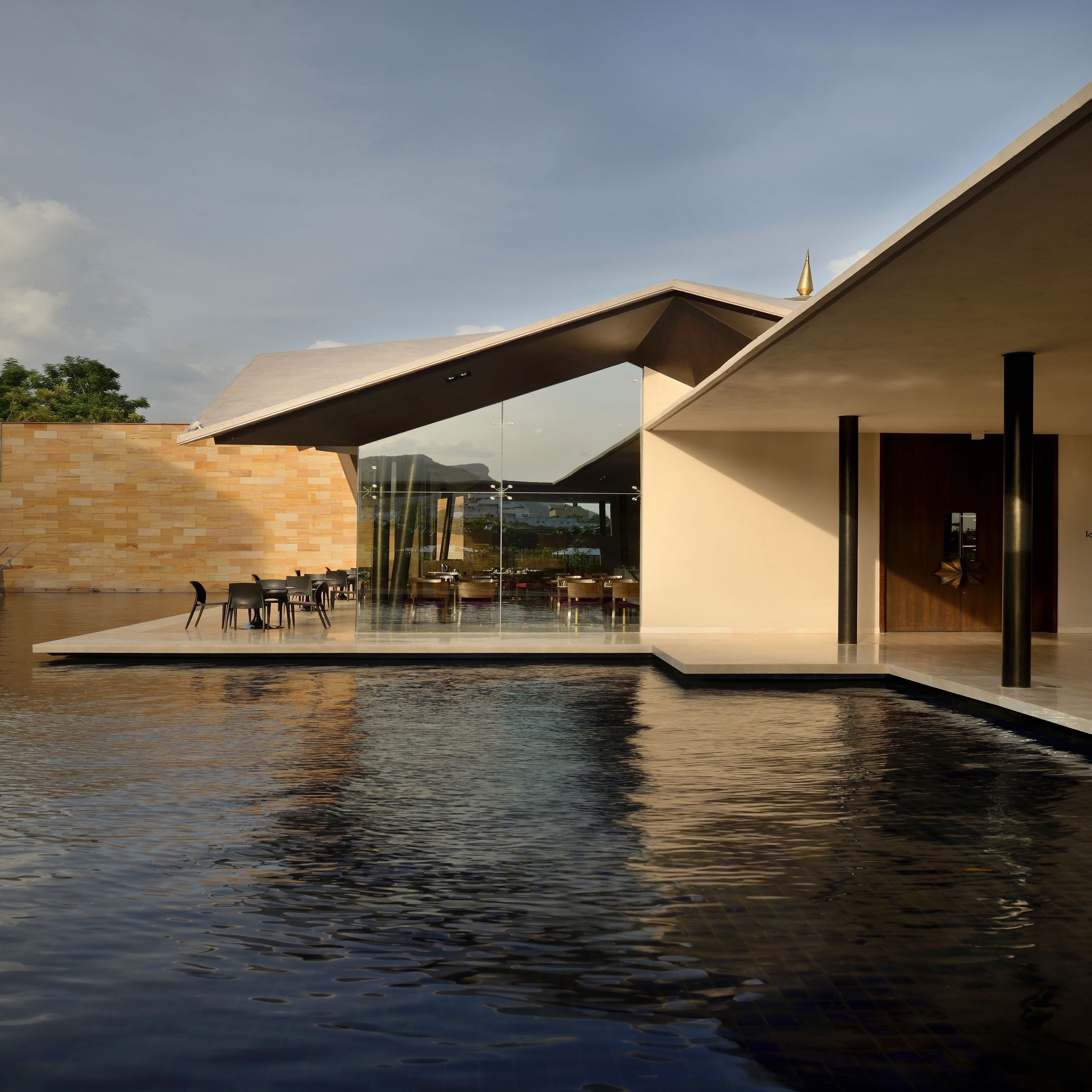 Um edifício moderno com piscina, área de estar ao ar livre e vista para as montanhas.