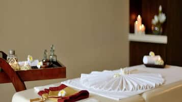 Experience serene relaxation in this tranquil massage room, featuring a massage table, wooden chair, and soothing ambiance.