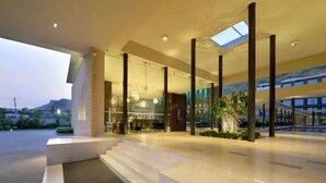 A modern hotel lobby with a glass facade, a bar area, and a staircase leading to the upper floor. - Marasa Sarovar Premiere Tirupati (Tirupati)