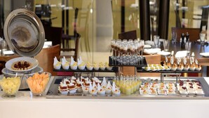 A buffet with various food items and a glass display case. - Marasa Sarovar Premiere Tirupati (Tirupati)