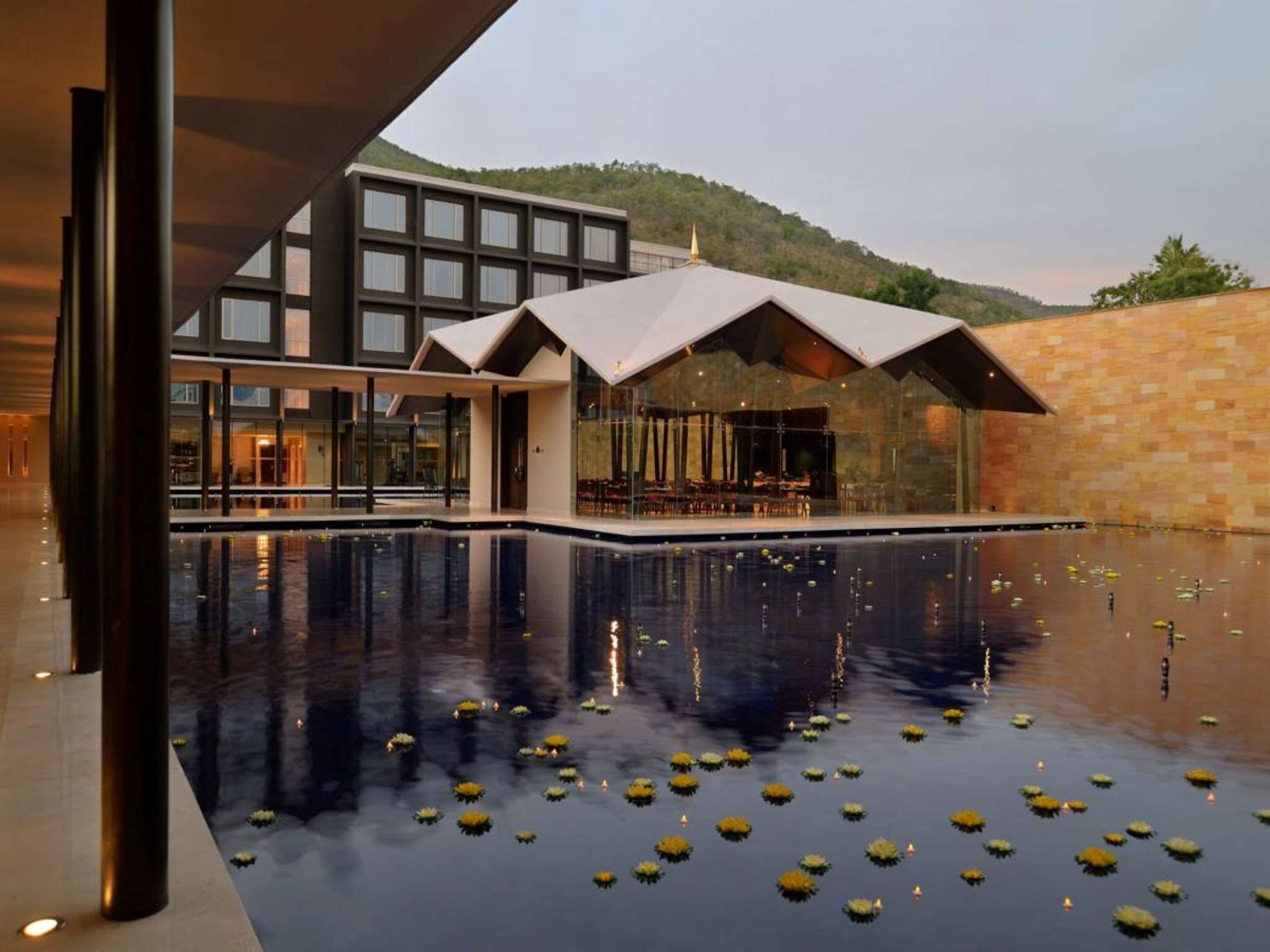 Um edifício moderno com uma piscina rodeada por plantas de lótus.