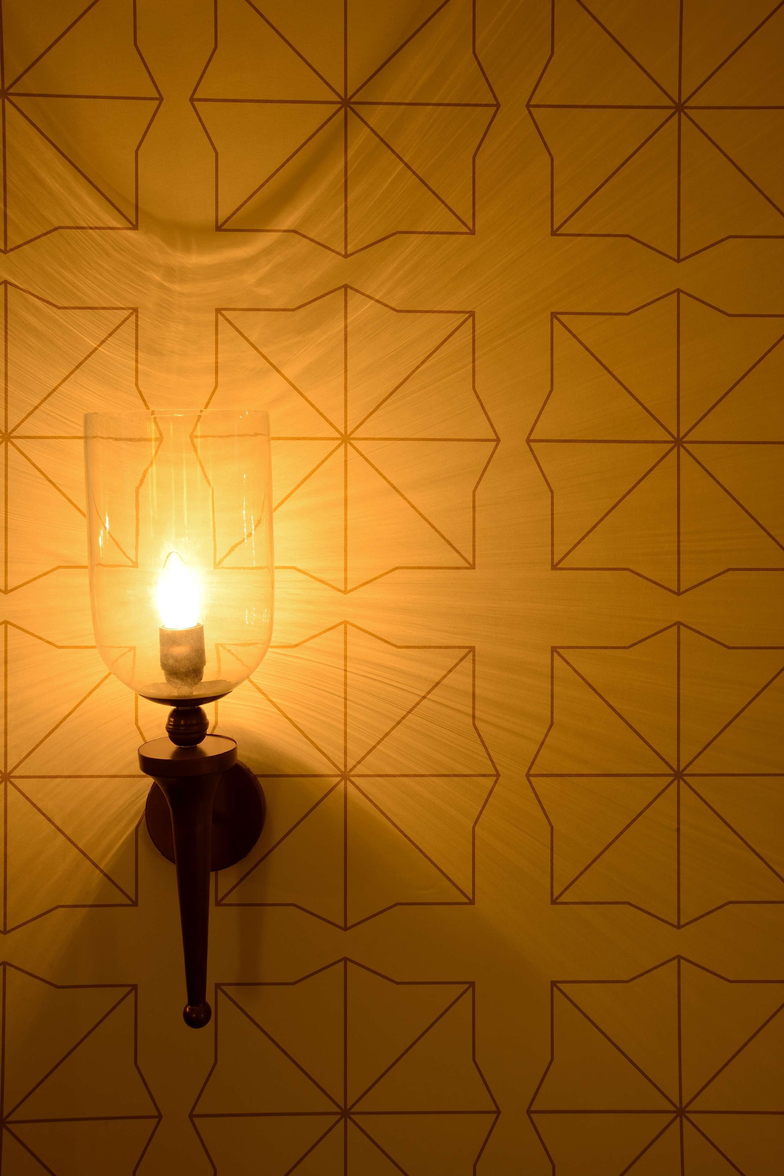 Eine Wandleuchte vor einem Hintergrund mit geometrischem Muster.