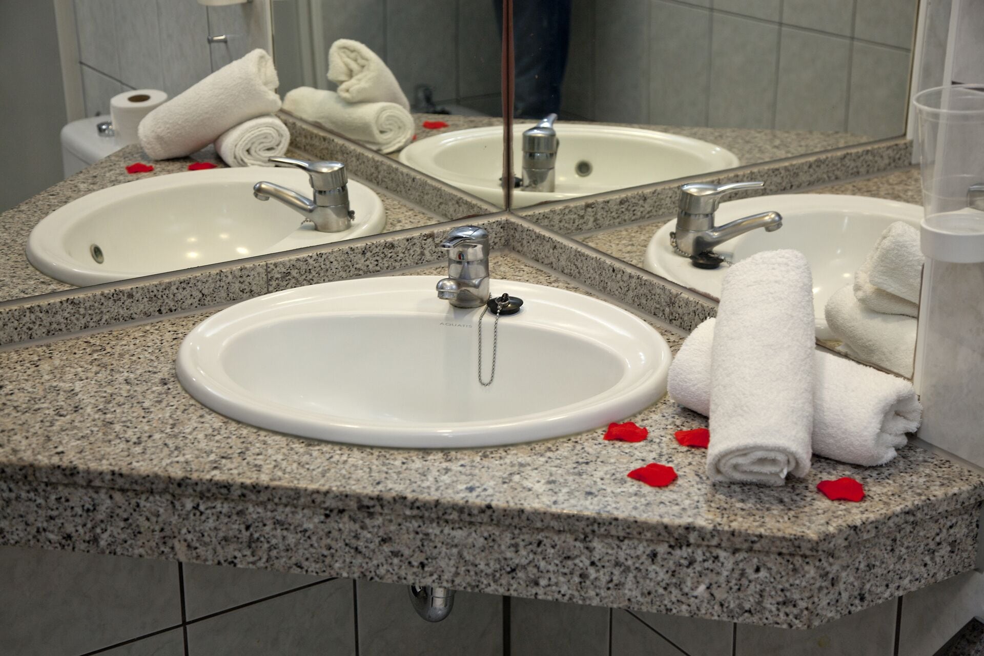 A bathroom with two sinks, a mirror, and towels.