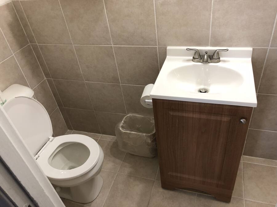 Un bagno piccolo con il water, un lavandino e un cestino.
