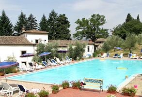 Una piscina al aire libre de temporada, sombrillas, tumbonas