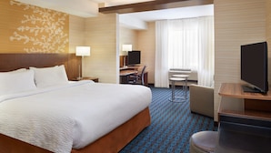 A hotel room with a large bed, a desk with a chair, a television, and a view of the outdoors through a window. - Fairfield Inn & Suites by Marriott Barrie (Barrie)