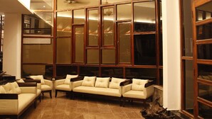 Amplia sala de estar con techo alto, ventanas grandes y una lámpara moderna.
