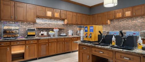 A modern kitchen with wooden cabinets, a built-in waffle iron station, and a coffee machine.