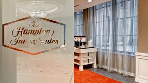 Zona de recepción de hotel con un cartel que dice "Hampton Inn & Suites".