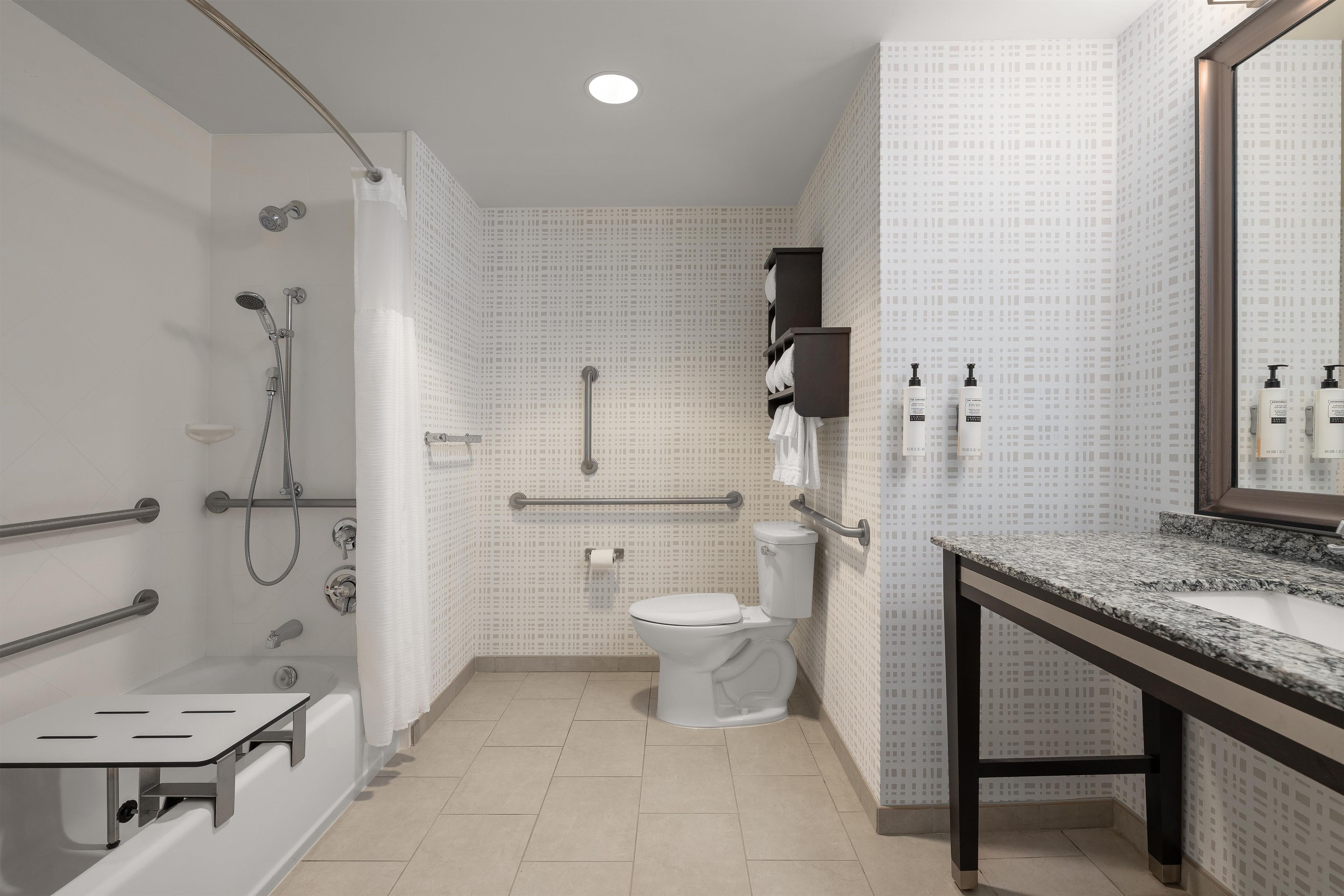 Un baño moderno con ducha, inodoro y lavamanos.