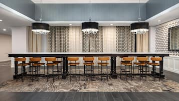 A conference room with a long table, multiple chairs, and three pendant lights.