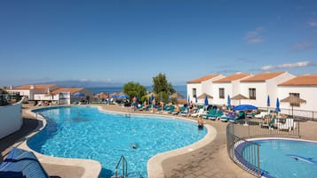 Una piscina al aire libre, tumbonas