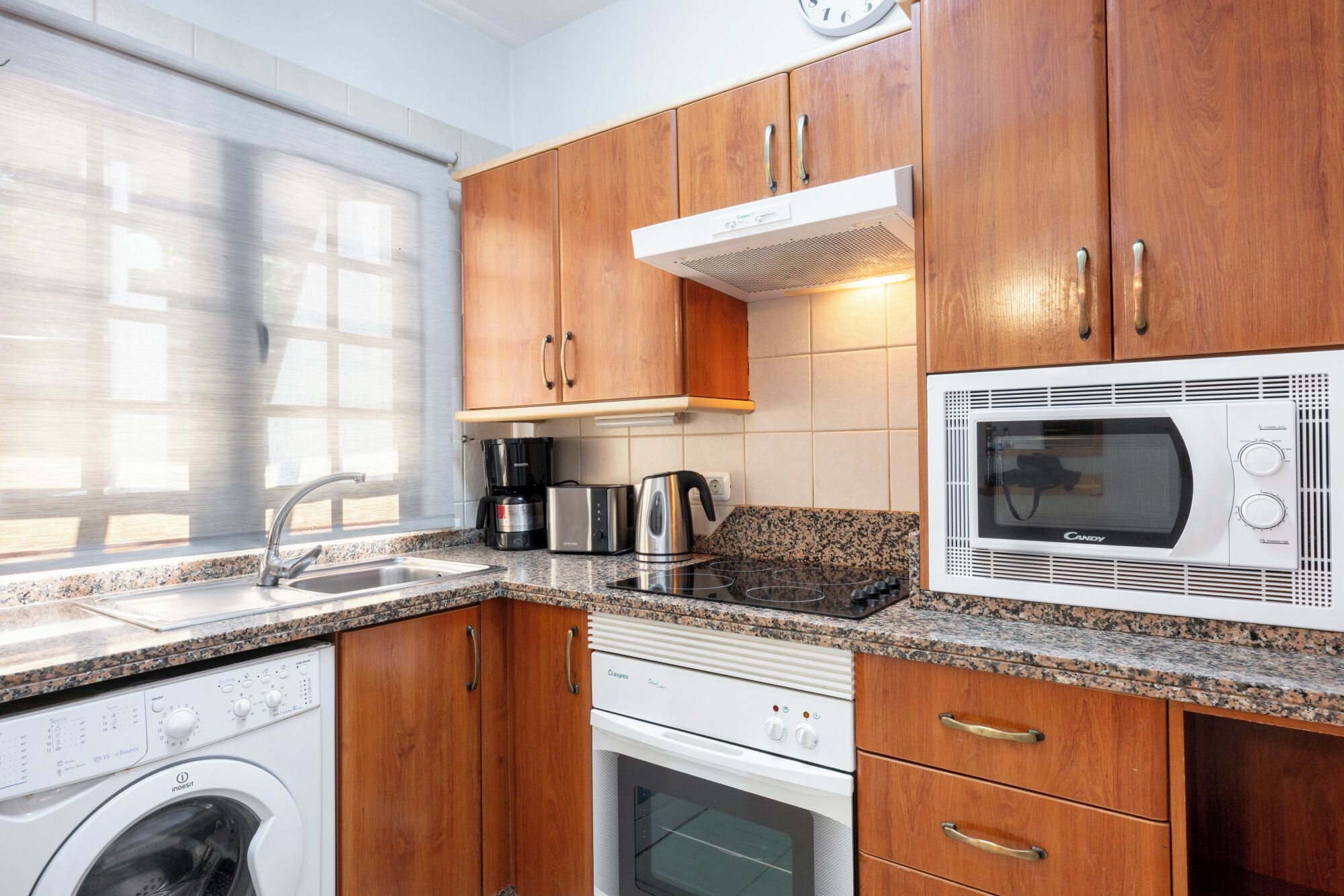 Cafetera o tetera, frigorífico, microondas y placa de cocina