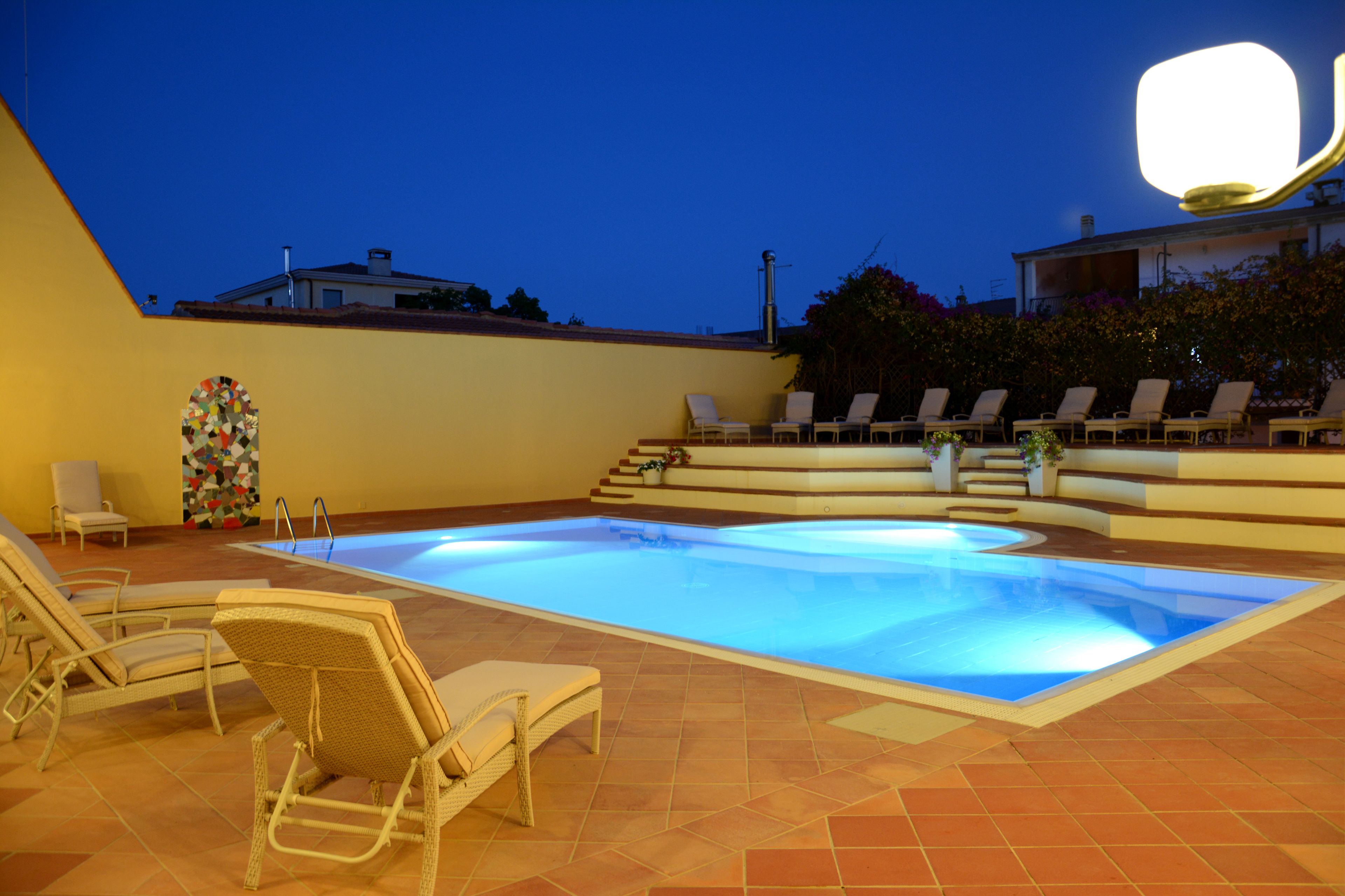 A swimming pool with lounge chairs and a decorative wall.