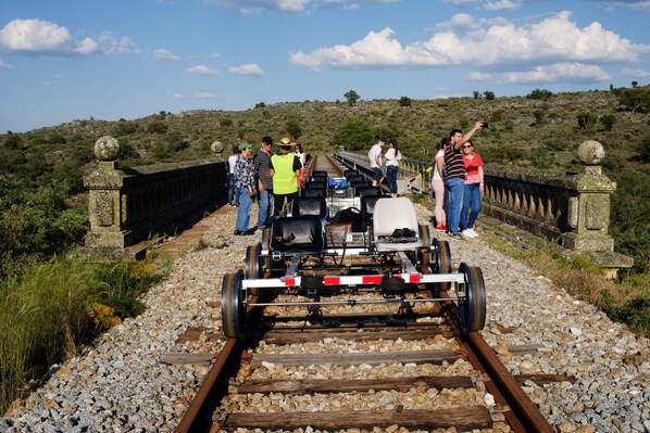 A train on tracks with people standing on the bridge. - Sever Rio Hotel (Marvao)