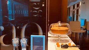 Een buffet met diverse soorten eten, waaronder een taart en plakjes vlees, gepresenteerd in een vitrine.