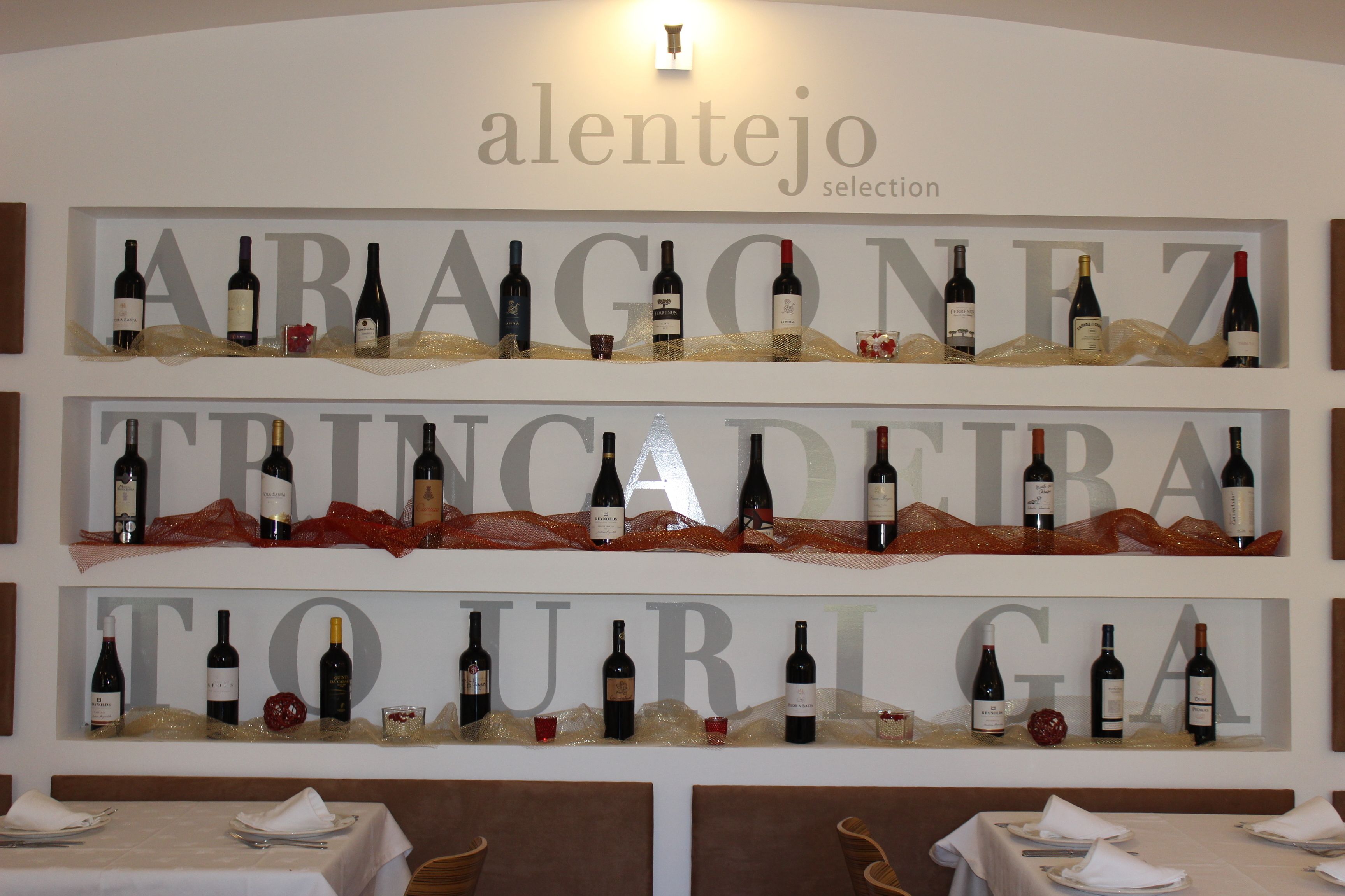 Interior de un restaurante con una pared mostrando botellas de vino y el nombre 'Alentejo Selection'.