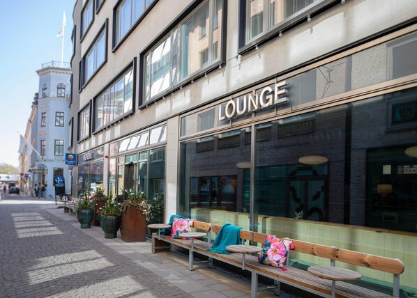 Un salon doté d’un espace extérieur aménagé, de grandes fenêtres et d’une façade remarquable.