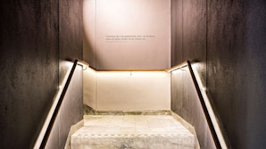 Eine Marmortreppe mit Handlauf und einer Wand mit Schrift.