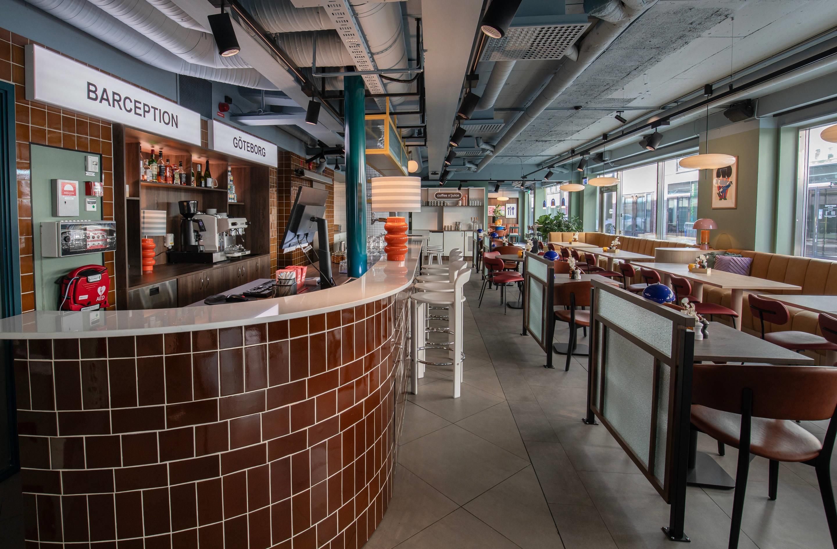 Una cafetería con mostrador, zona de estar y un desfibrilador externo automático visible.