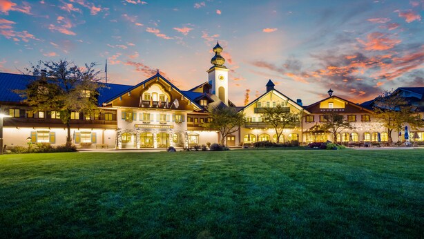 A large, multi-story hotel with a prominent clock tower, well-lit outdoor areas, and a spacious lawn. - Bavarian Inn of Frankenmuth (Frankenmuth)