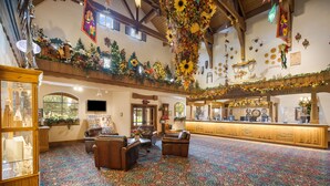 A spacious lobby with a patterned carpet, leather seating, a reception desk, and Christmas decorations. - Bavarian Inn of Frankenmuth (Frankenmuth)