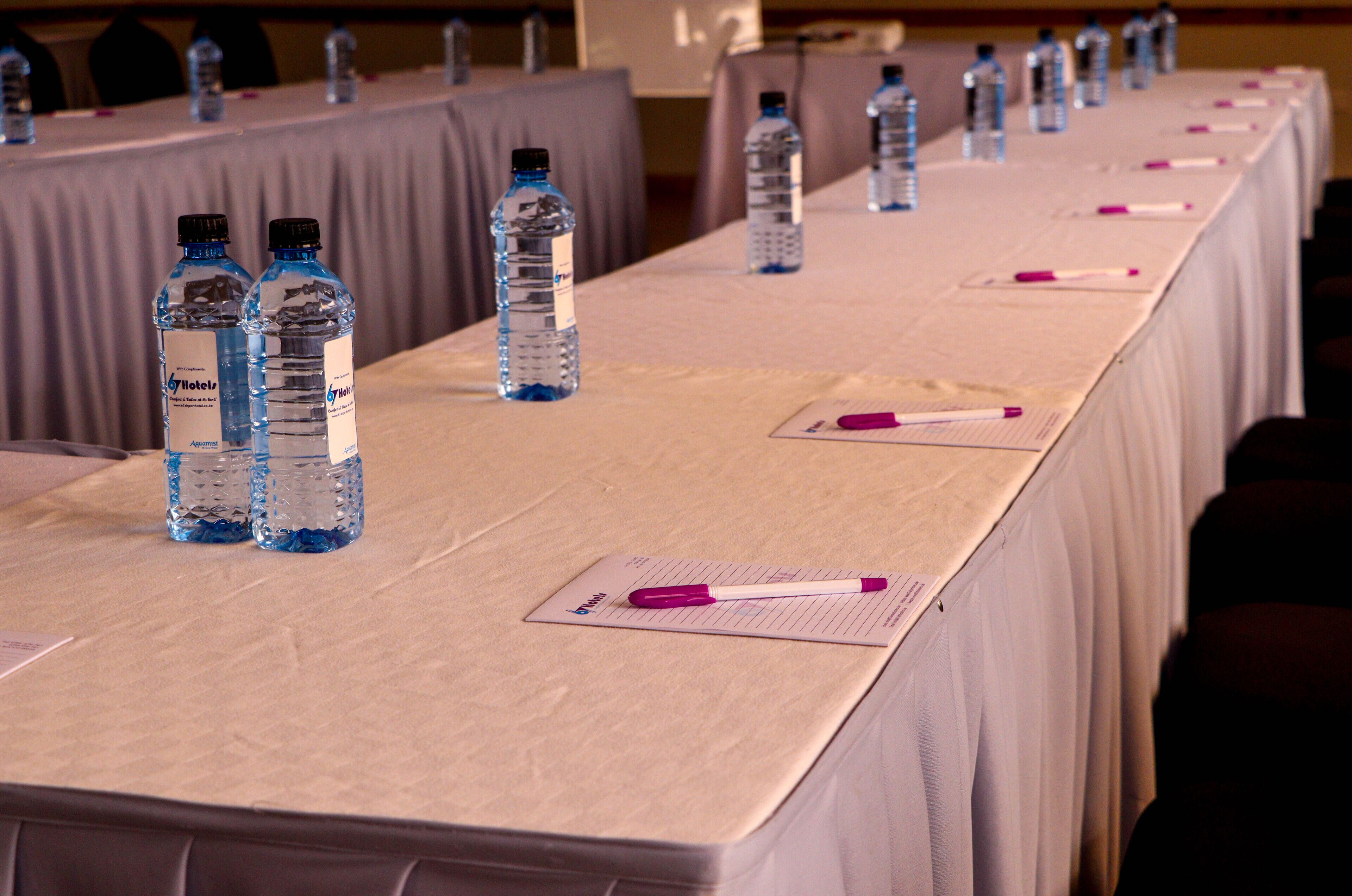 A conference table with water bottles and notepads.