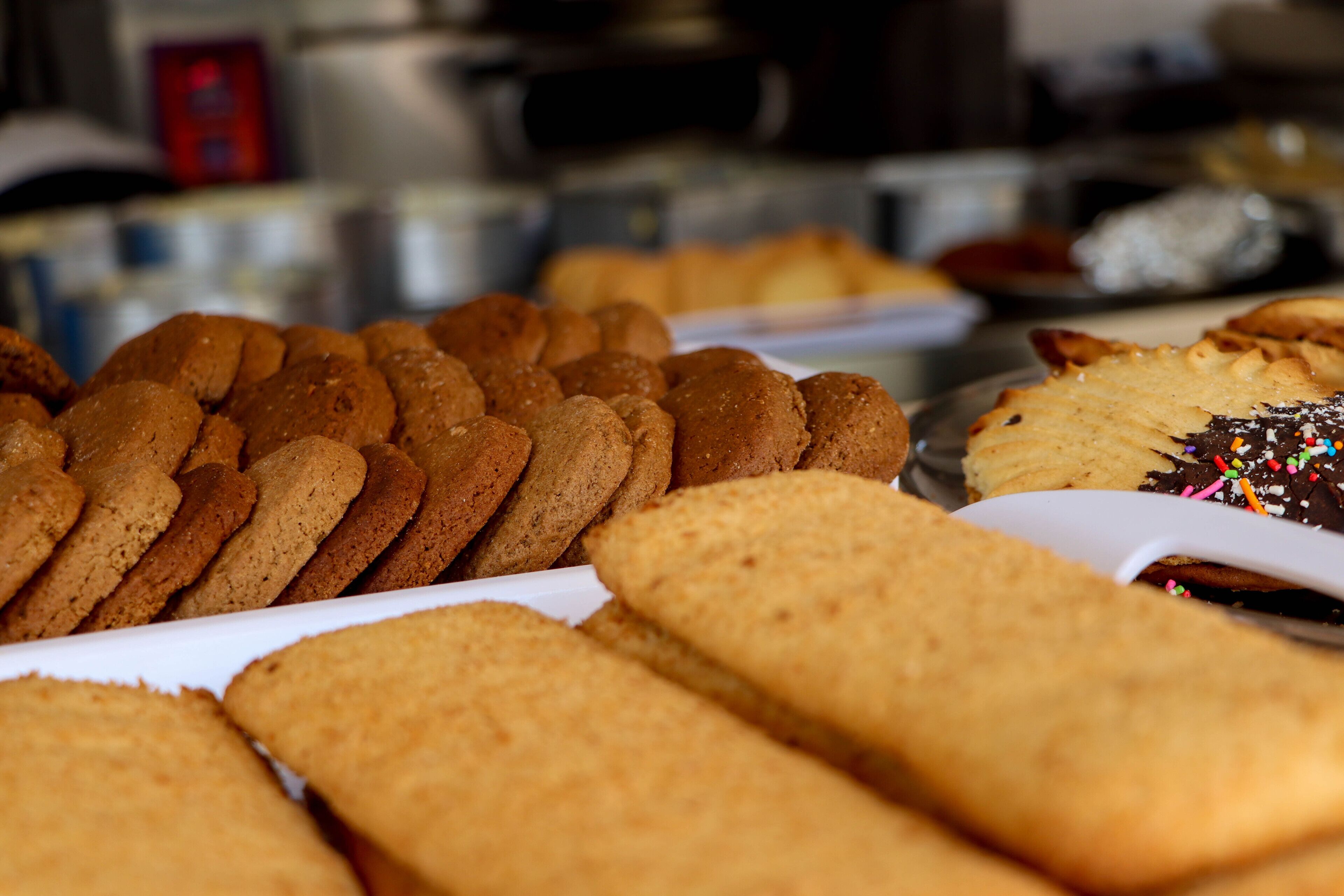 A variety of baked goods, including cookies and a cake with sprinkles, displayed on a tray.