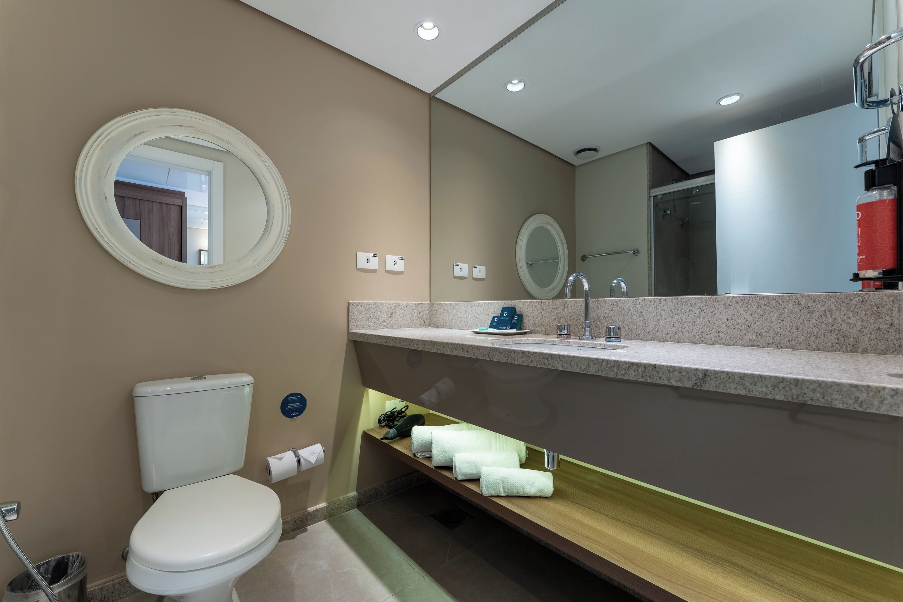 A modern bathroom with a toilet, sink, and shower.