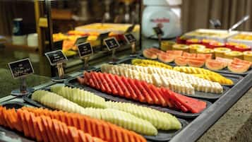 Un bufé con diversas frutas y verduras en rodajas.