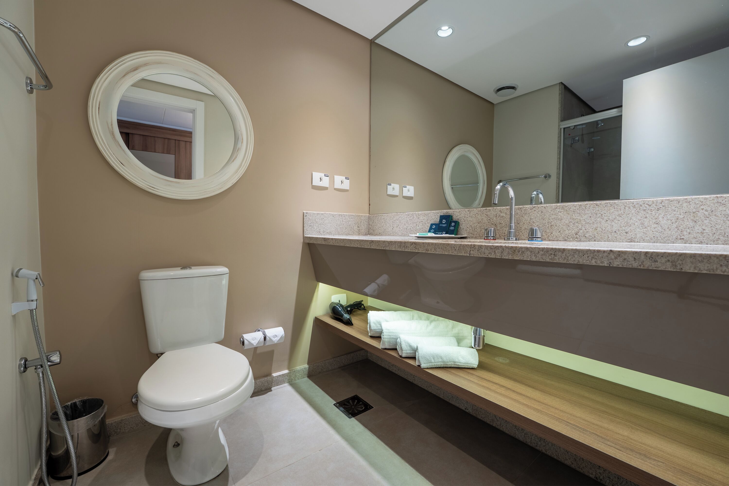 Un baño moderno con inodoro, lavamanos y ducha.