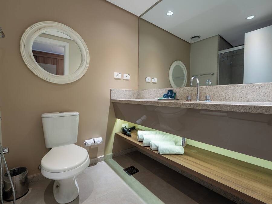 Un baño moderno con inodoro, lavamanos y ducha.