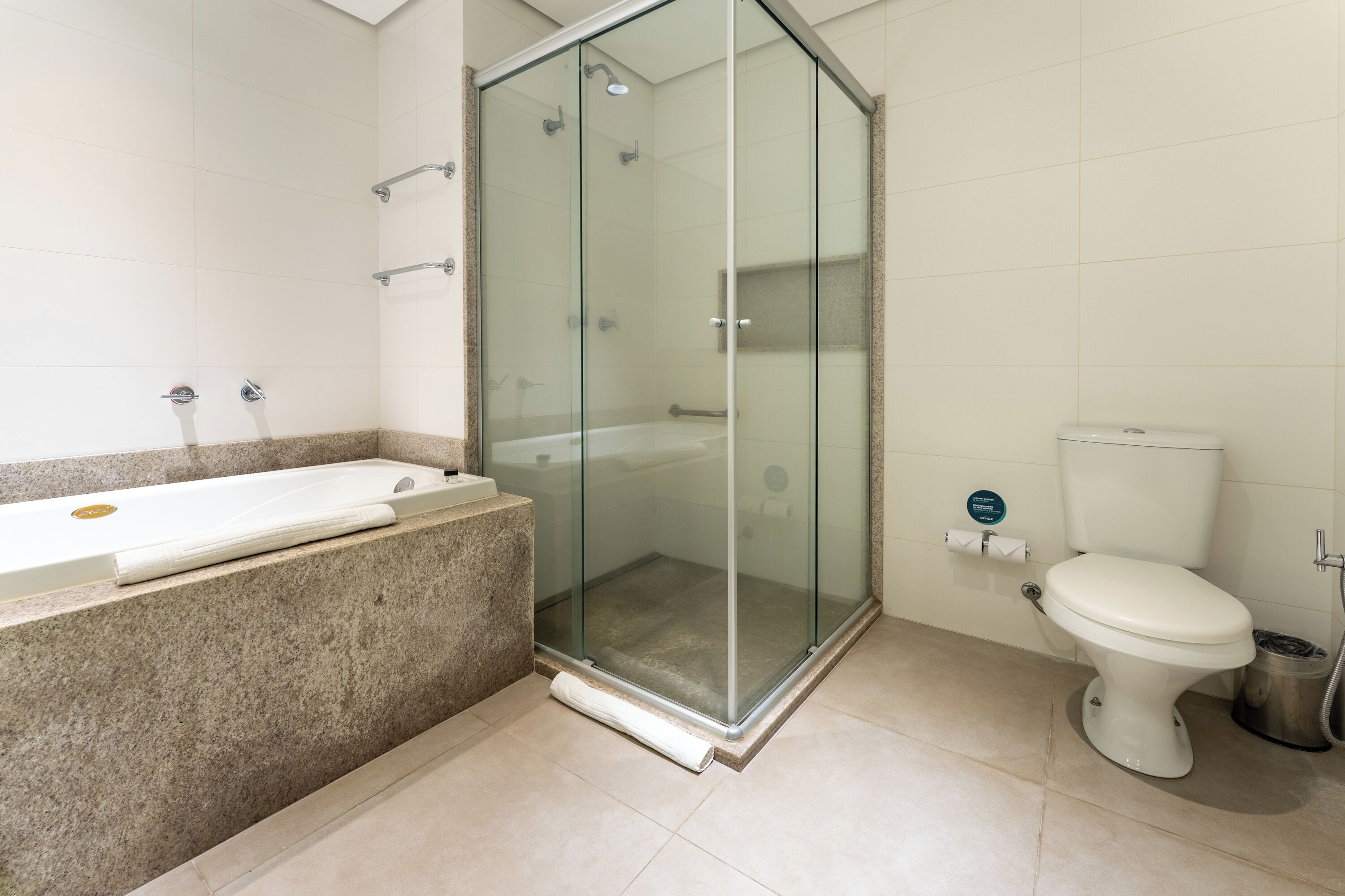 Un baño moderno con ducha de vidrio, bañera independiente y un inodoro.