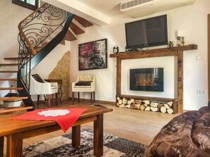 Suite Deluks, pemandangan kebun | Area keluarga | TV layar datar, buku, dan peralatan stereo