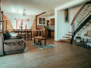 Suite – deluxe, hageutsikt | Oppholdsområde | Flatskjerm-TV, bøker og stereoanlegg