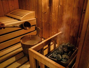 A sauna with wooden benches, a wooden bucket, and a container of ice. - Plitvice Luxury (Plitvicka Jezera)