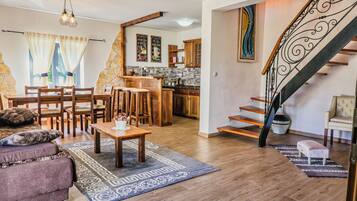 Deluxe Suite, Garden View | Living area | Flat-screen TV, books, stereo