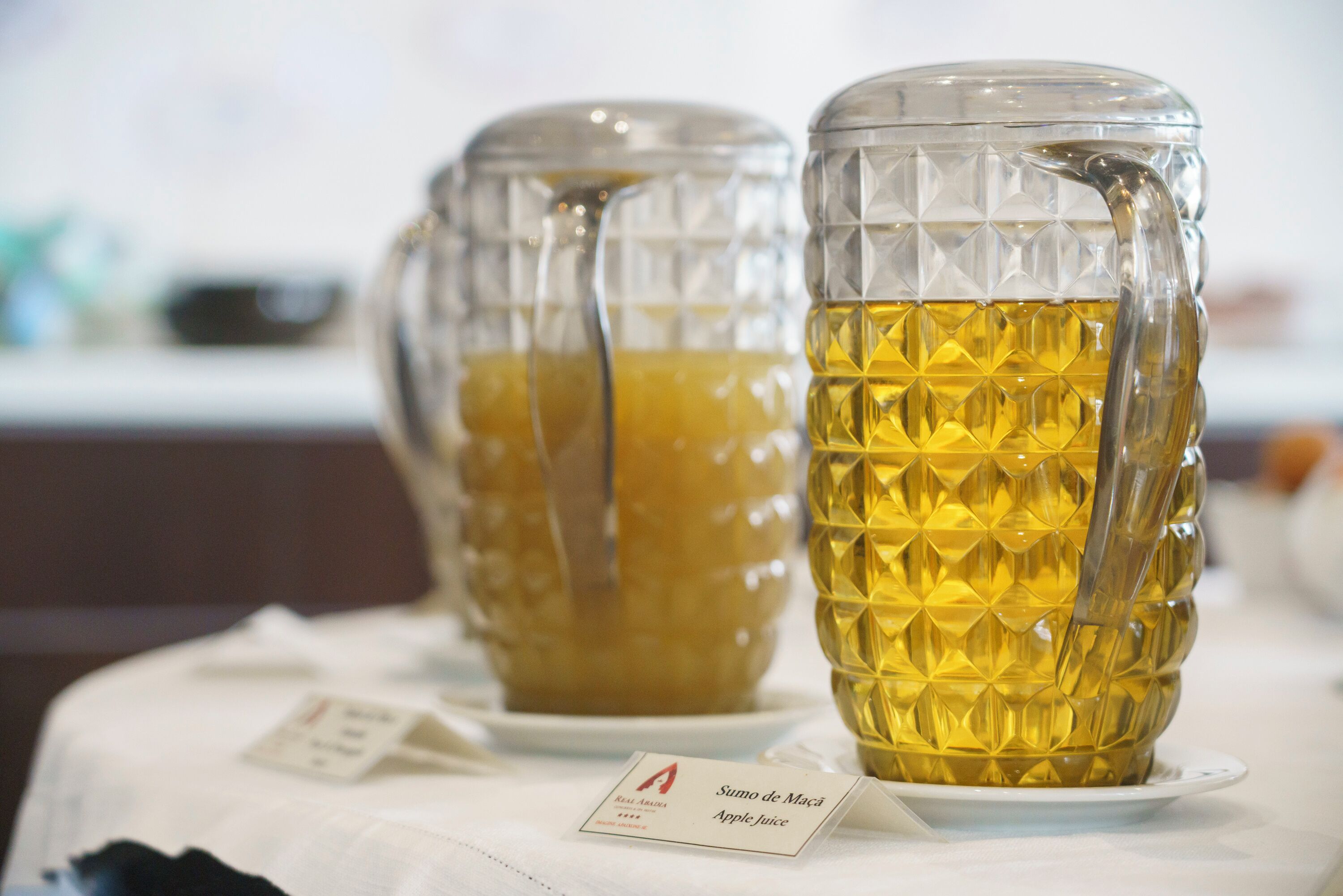 Dos recipientes de vidrio con etiquetas sobre una mesa.