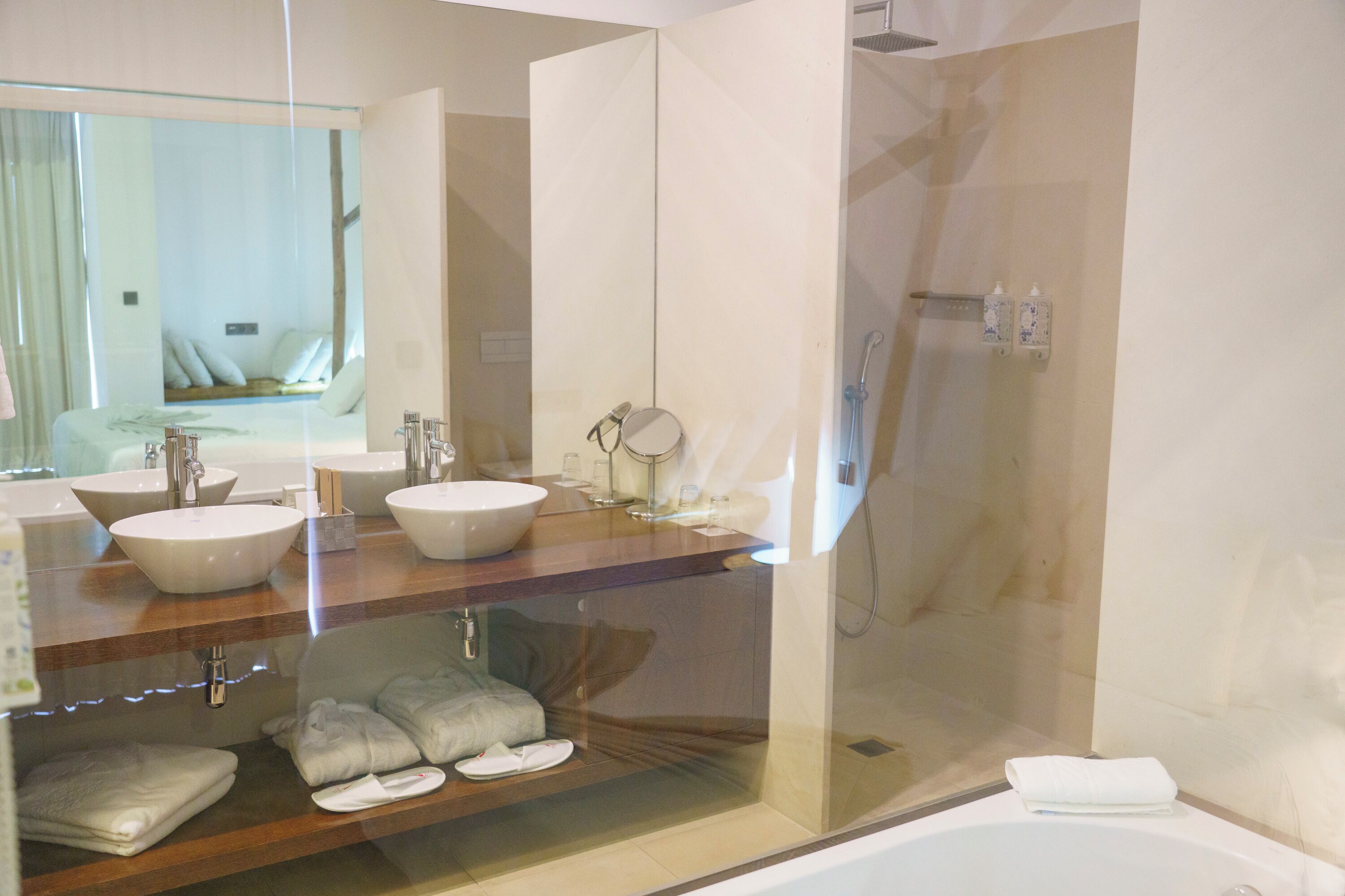 A modern bathroom with two large sinks, a glass-enclosed shower, and a bathtub.