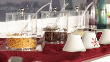 Una mesa de buffet con recipientes transparentes que contienen diversos alimentos y utensilios.