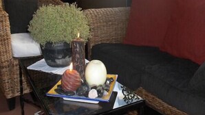 A living room with a sofa, a coffee table with a plant, candles, and decorative items.