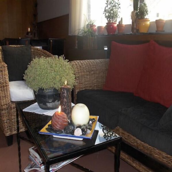 A living room with a sofa, a coffee table with a plant, candles, and decorative items.